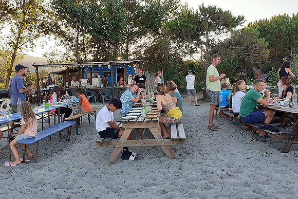 Familien auf Bierbänken am Strand