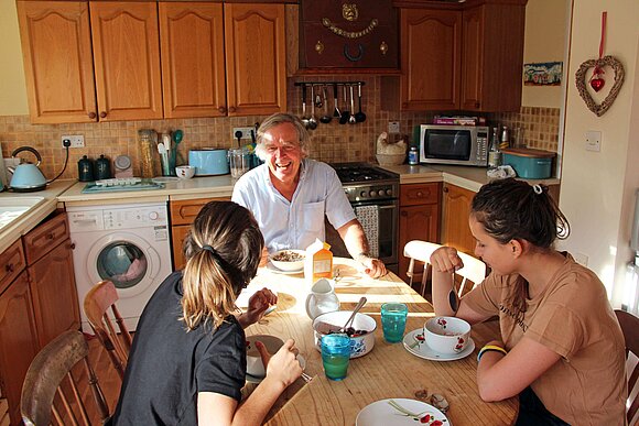 Schülerin und Gastfamilie in der Küche am Tisch
