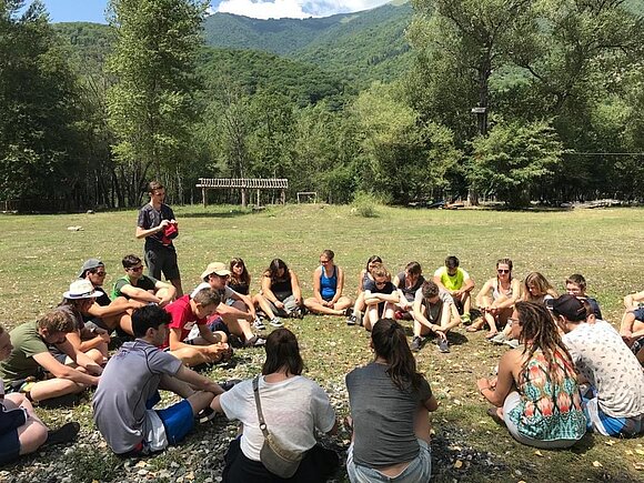 Jugendliche auf Wiese im Kreis