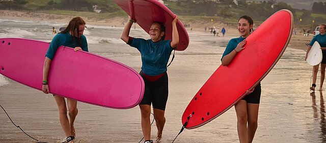 Surfen in Frankreich Drei Mädchen am Strand mit Surfbrettern