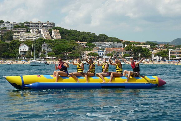 Jugendlich auf Bananen-Boot im Meer