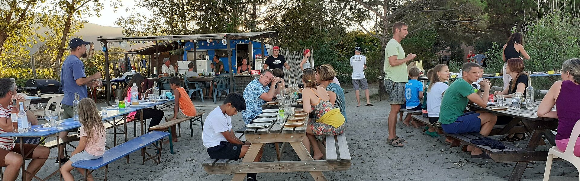 Familien essen gemeinsam am Strand