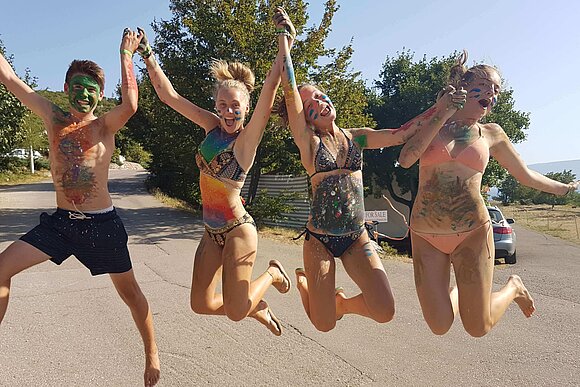 junge Menschen hüpfen vor Strand