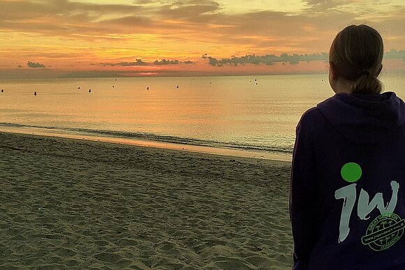 Person vor Sonnenuntergang mit Logo Jugendwerk Pulli