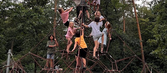 Kinder auf einem Spielplatz auf einem Klettergerüst auf der Freizeit