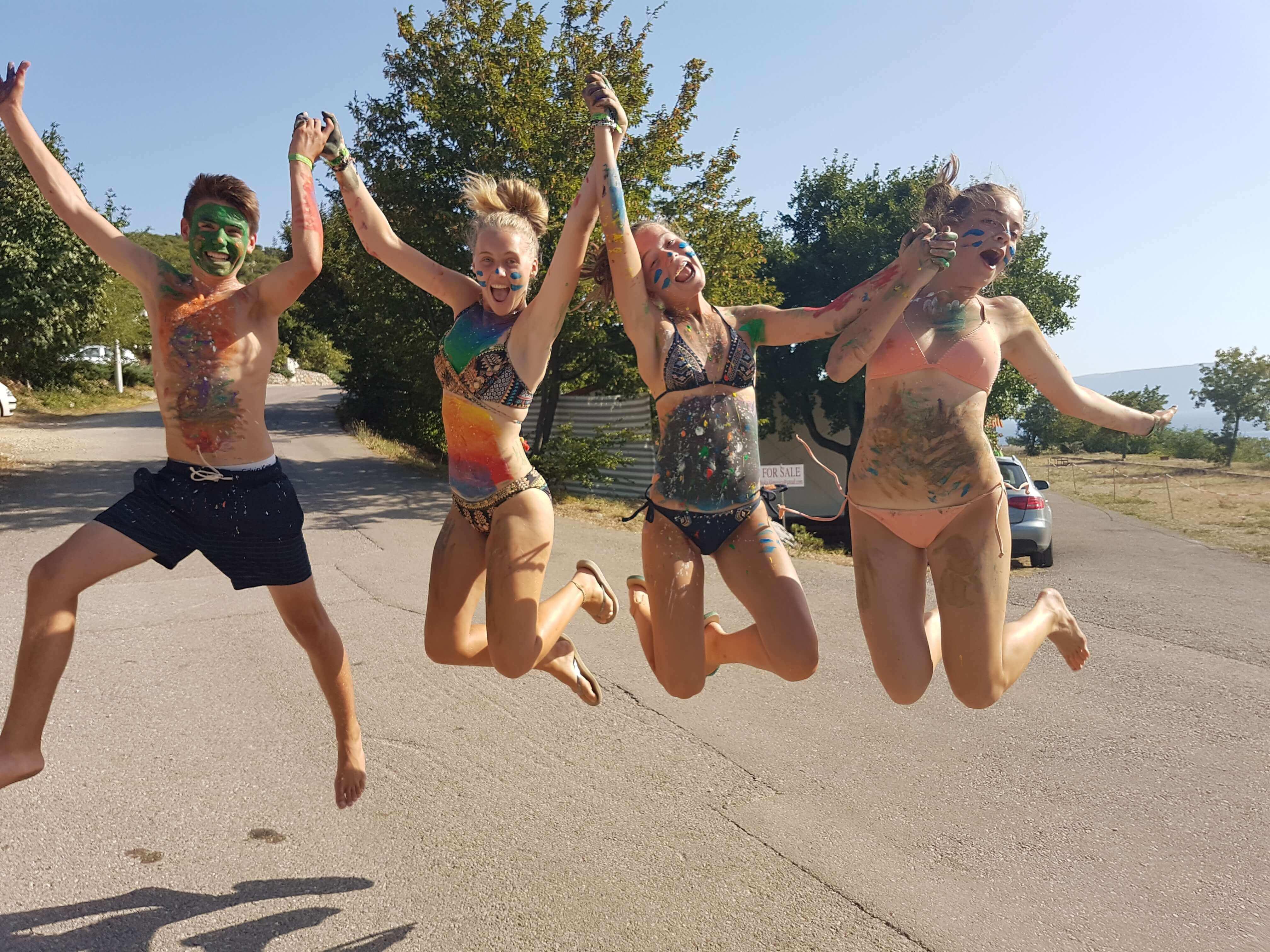 junge Menschen hüpfen vor Strand